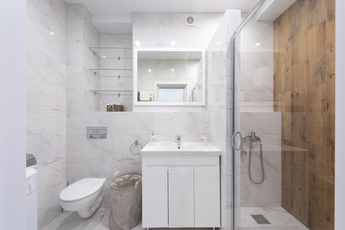 Ruime badkamer met marmeren tegels en glazen douchewand